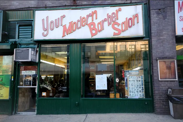 A photo of a Harlem barbershop called "Your Modern Barber Saloon"